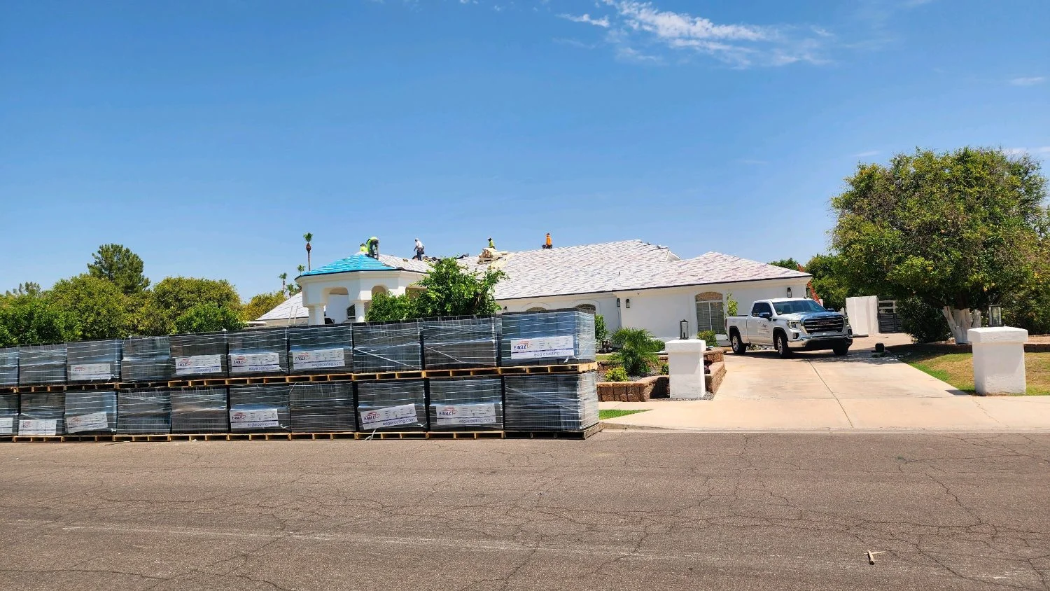 Pallets of new roof tile staged in a driveway