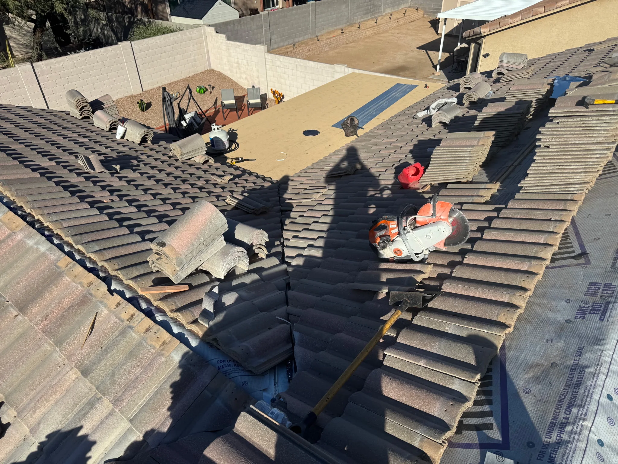 Tile roof mid-project with tile stacked aside and new high-temperature underlayment exposed