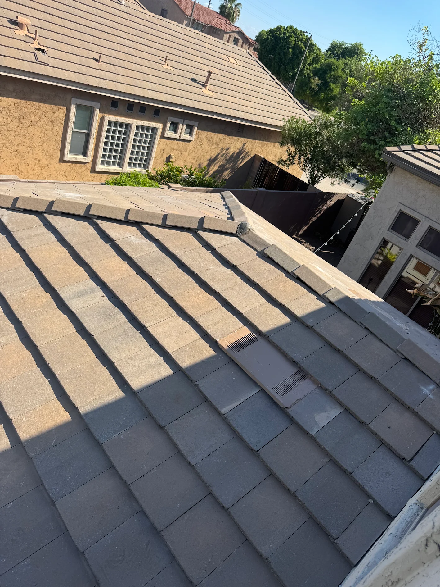 Looking down the hip of a finished flat concrete tile roof