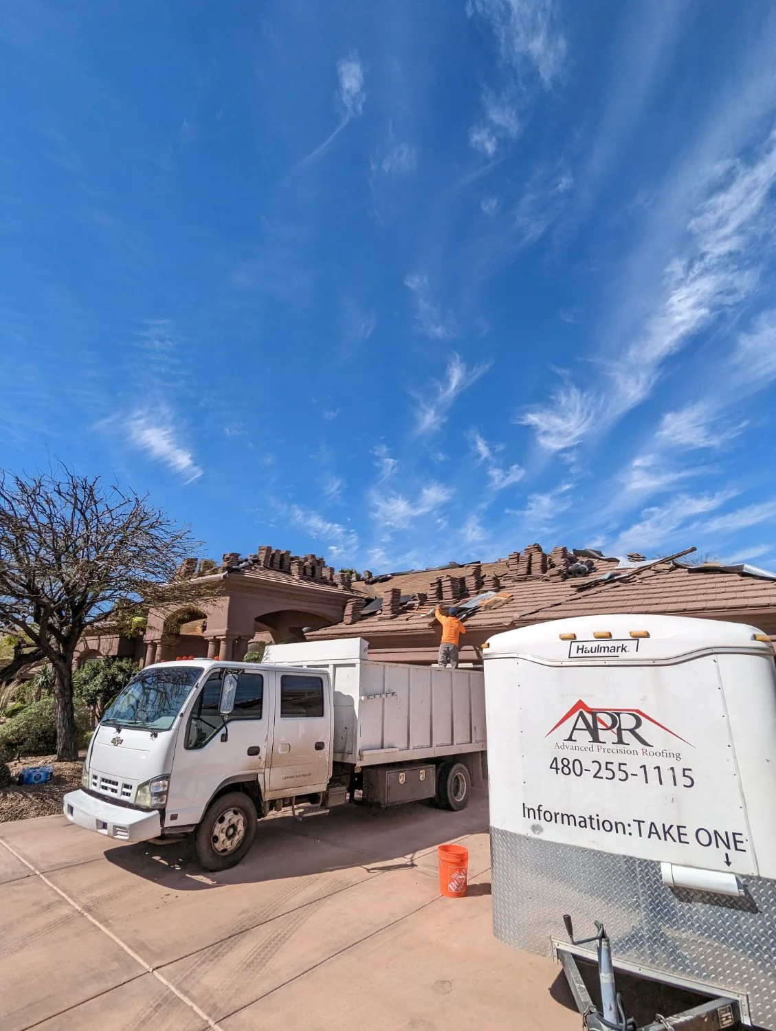 Dump truck removing tile roof tear-off debris
