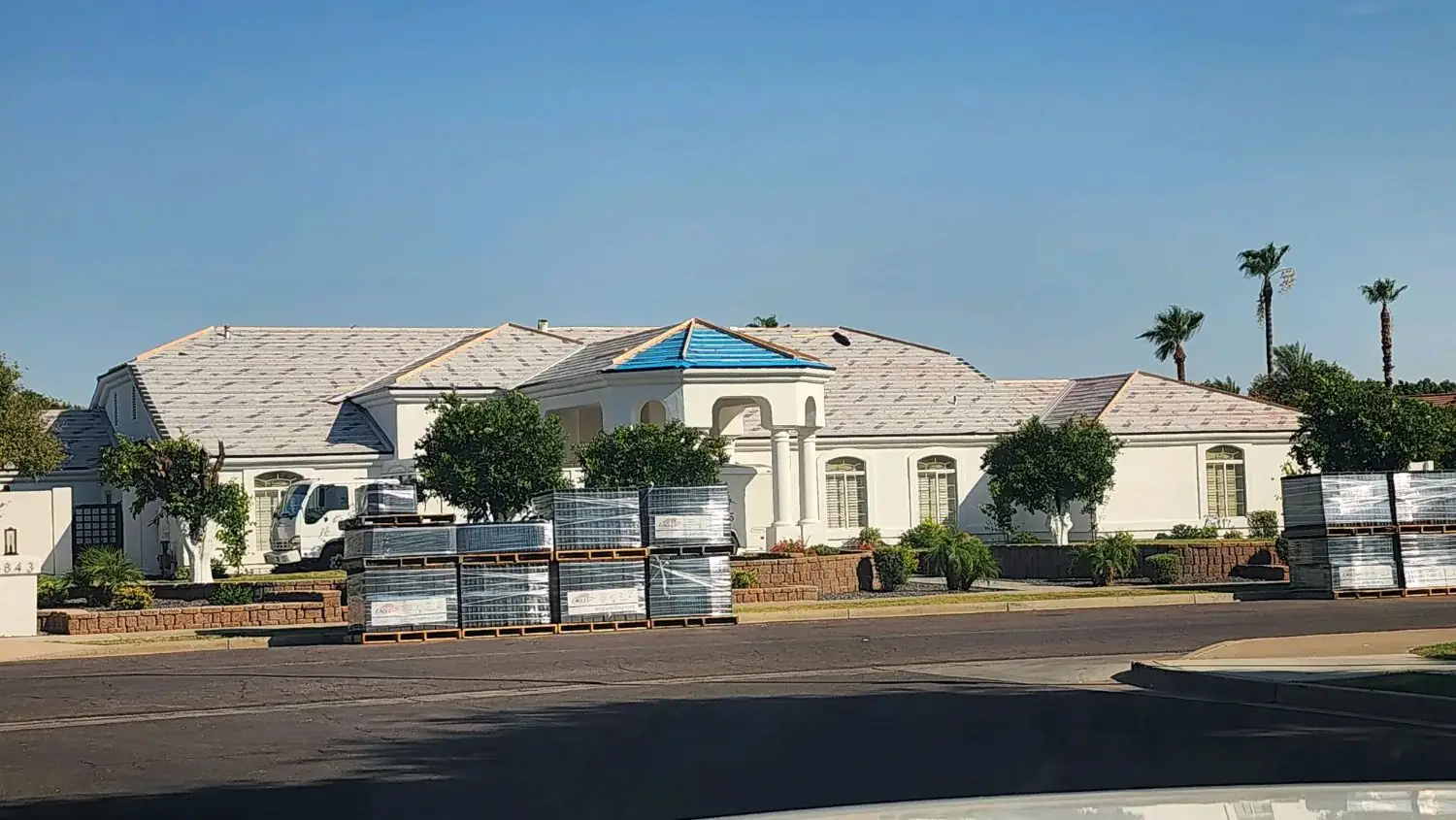 Roofing materials staged outside an estate home